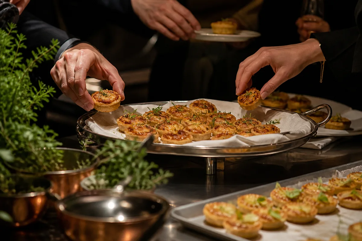 Convives se servant de bouchées chaudes sur un plateau de service en soirée